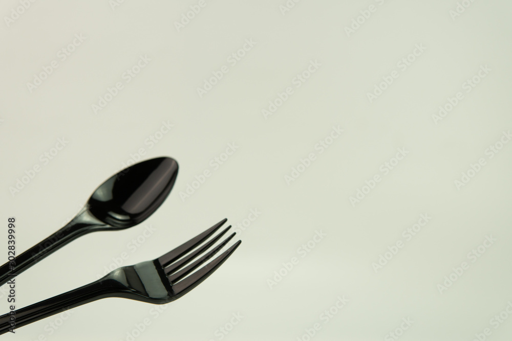 Selective focus of black shine spoon and fork with white background. Food or restaurant concept. Selective focus of black shine spoon and fork with white background. Food or restaurant concept.