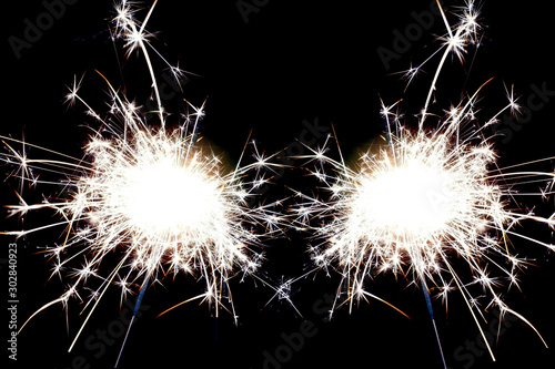 Two christmas sparklers on black background.