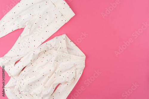 baby clothes on pink background top view