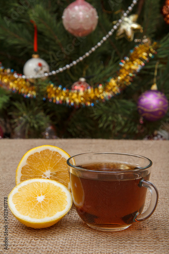 Fototapeta Naklejka Na Ścianę i Meble -  Cup of tea and pieces of lemon on sackcloth background