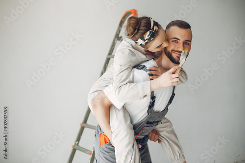 Family repairs. Couple at home. Woman in a overalls