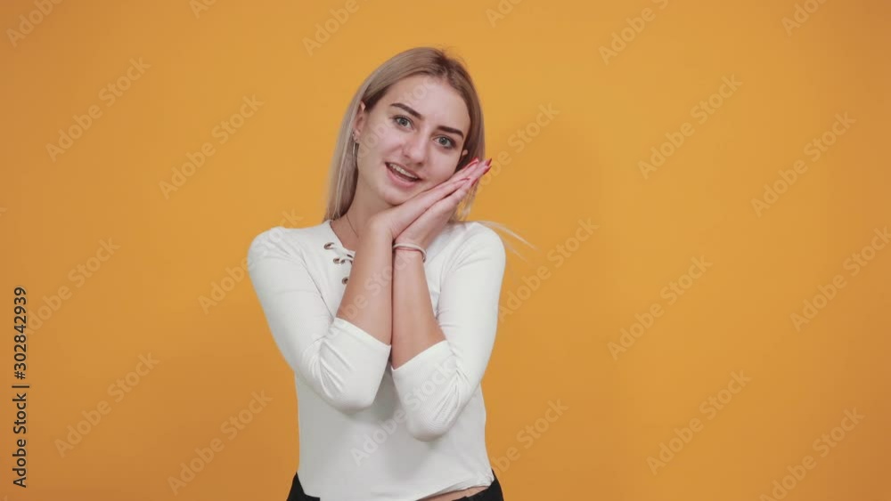Gorgeous young caucasian girl making sleep gesture in dorable expression wearing pretty white shirt on isolated yellow background Gorgeous young caucasian girl making sleep gesture in dorable expression wearing pretty white shirt on isolated yellow background
