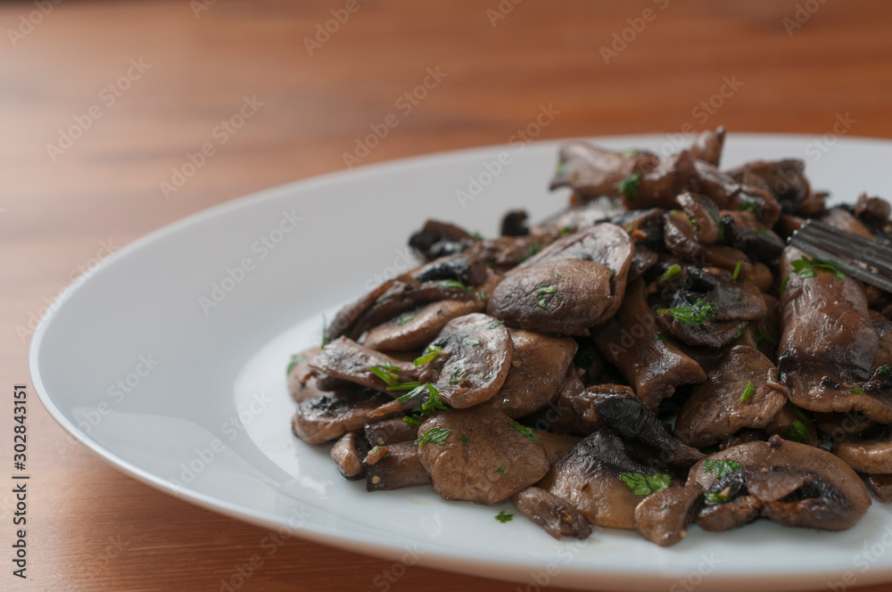 Sauteed champignon mushroom with chopped parsley, macro Sauteed champignon mushroom with chopped parsley, macro