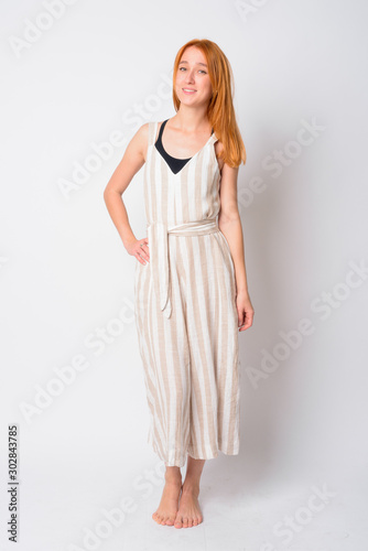 Full body shot of happy young beautiful redhead woman smiling