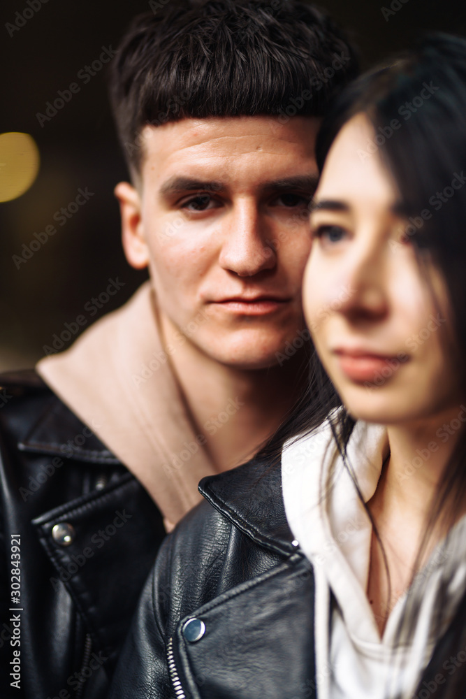 Portrait of sensual young couple in love. Young couple in love hug each other on the black background with lights. Together. Love, romantic, passion, tenderness concept. Portrait of sensual young couple in love. Young couple in love hug each other on the black background with lights. Together. Love, romantic, passion, tenderness concept.
