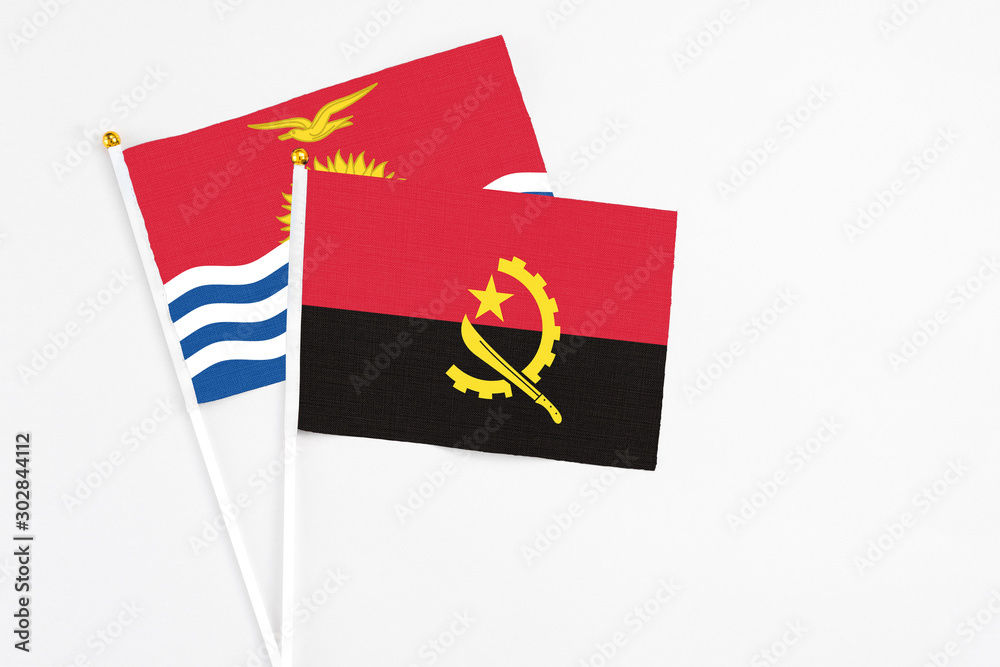 Angola and Kiribati stick flags on white background. High quality fabric, miniature national flag. Peaceful global concept.White floor for copy space. Angola and Kiribati stick flags on white background. High quality fabric, miniature national flag. Peaceful global concept.White floor for copy space.
