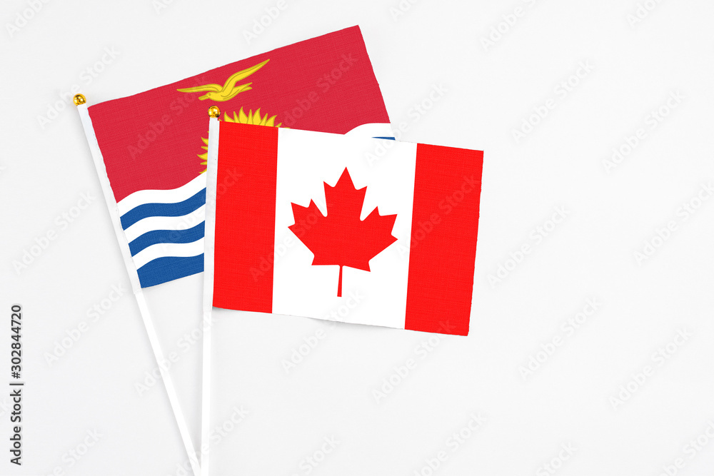 Canada and Kiribati stick flags on white background. High quality fabric, miniature national flag. Peaceful global concept.White floor for copy space. Canada and Kiribati stick flags on white background. High quality fabric, miniature national flag. Peaceful global concept.White floor for copy space.