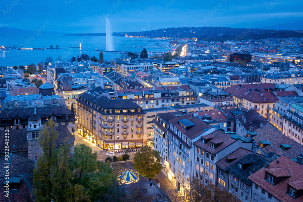 Aerial view of Geneva City center and Jet d'eau by night on World Diabetes Day.  This photo was taken shortly after sunset, at the blue hour, from the top of the tower of St. Peter's Cathedral. 