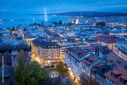Aerial view of Geneva City center and Jet d'eau by night on World Diabetes Day. This photo was taken shortly after sunset, at the blue hour, from the top of the tower of St. Peter's Cathedral. 