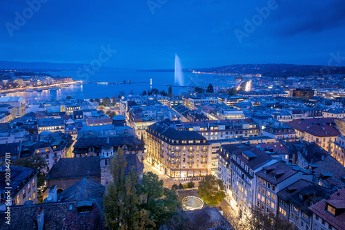Aerial view of Geneva City center and Jet d'eau by night on World Diabetes Day.  This photo was taken shortly after sunset, at the blue hour, from the top of the tower of St. Peter's Cathedral. 