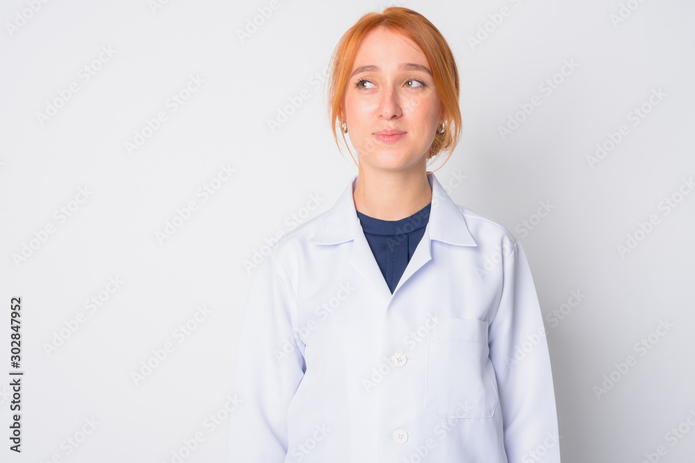 Portrait of young beautiful redhead woman doctor thinking Portrait of young beautiful redhead woman doctor thinking