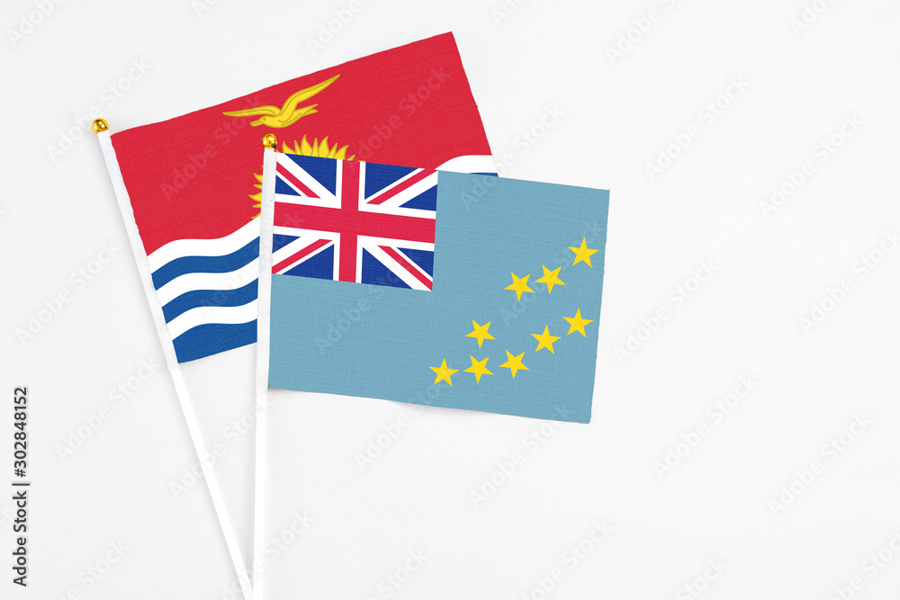 Tuvalu and Kiribati stick flags on white background. High quality fabric, miniature national flag. Peaceful global concept.White floor for copy space. Tuvalu and Kiribati stick flags on white background. High quality fabric, miniature national flag. Peaceful global concept.White floor for copy space.