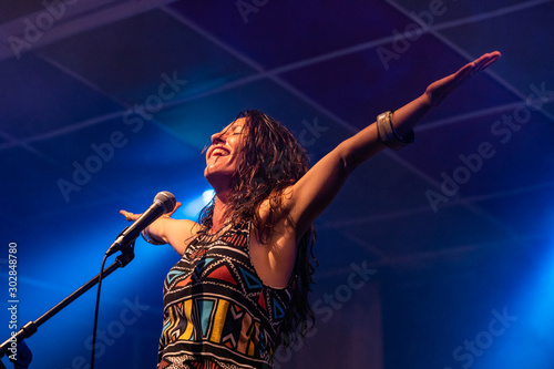 Cuadro en lienzo a female musician is viewed from a low angle as she sings and smiling with the a