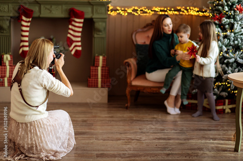 Woman photographer photographs family in Christmas holiday