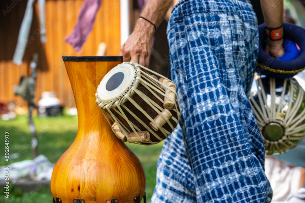 A close up on spiritual man standing and holding traditional music  instruments during a live music performance While wearing traditional blue  and white pants Stock Photo | Adobe Stock