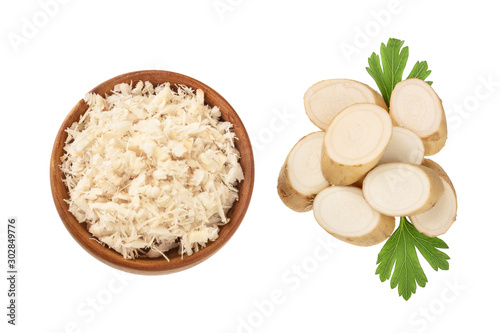 Tela Horseradish root grated in wooden bowl with slices isolated on white background