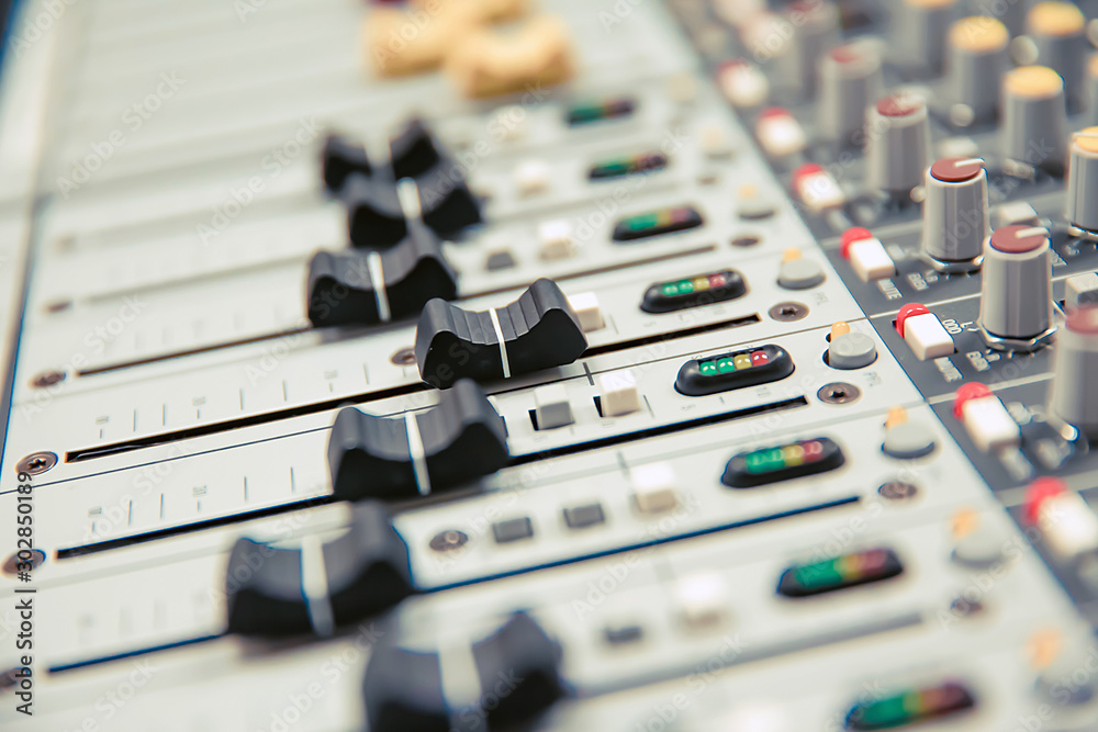 Close-up volume slide of digital sound mixer in the studio for recording, editing, and Sound system control concept. Close-up volume slide of digital sound mixer in the studio for recording, editing, and Sound system control concept.