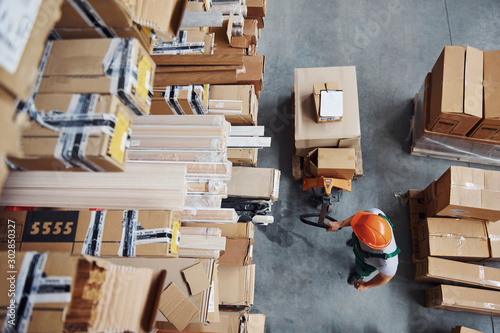 Top view of male worker in warehouse with pallet truck © standret