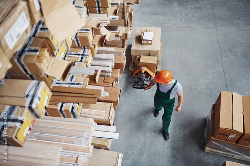 Top view of male worker in warehouse with pallet truck