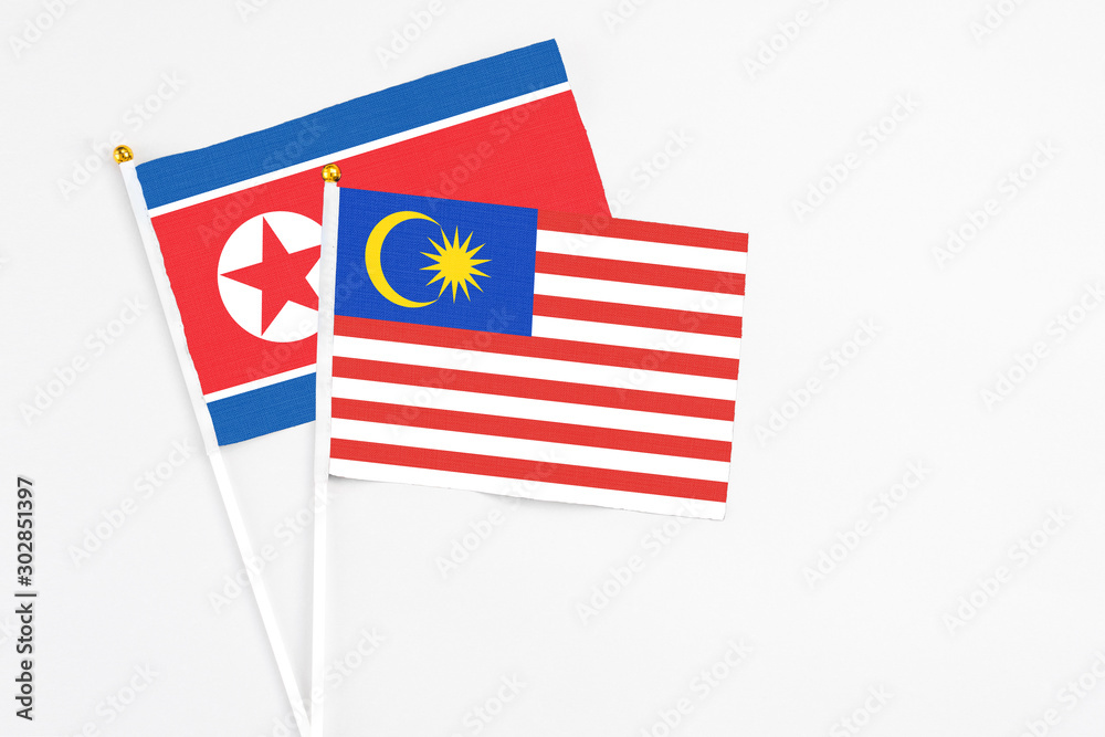 Malaysia and North Korea stick flags on white background. High quality fabric, miniature national flag. Peaceful global concept.White floor for copy space. Malaysia and North Korea stick flags on white background. High quality fabric, miniature national flag. Peaceful global concept.White floor for copy space.