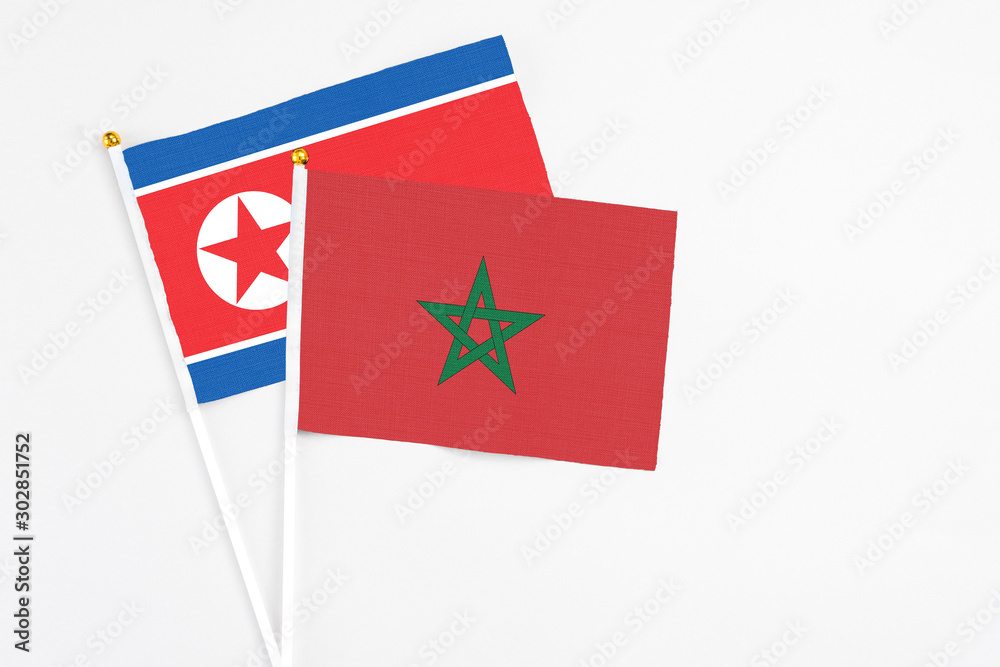 Morocco and North Korea stick flags on white background. High quality fabric, miniature national flag. Peaceful global concept.White floor for copy space. Morocco and North Korea stick flags on white background. High quality fabric, miniature national flag. Peaceful global concept.White floor for copy space.