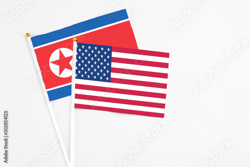 United States and North Korea stick flags on white background. High quality fabric, miniature national flag. Peaceful global concept.White floor for copy space.