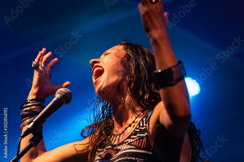 Cuadro en lienzo A female musician is viewed from a low angle as she sings, with open mouth in mi