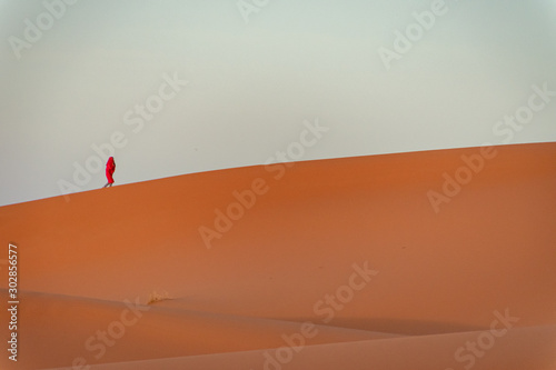Person walking through the dunes of the Sahara desert. Morocco