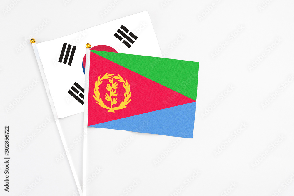 Eritrea and South Korea stick flags on white background. High quality fabric, miniature national flag. Peaceful global concept.White floor for copy space. Eritrea and South Korea stick flags on white background. High quality fabric, miniature national flag. Peaceful global concept.White floor for copy space.