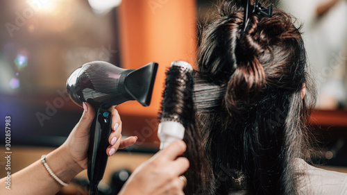 Hairdresser Curling Woman’s Hair
