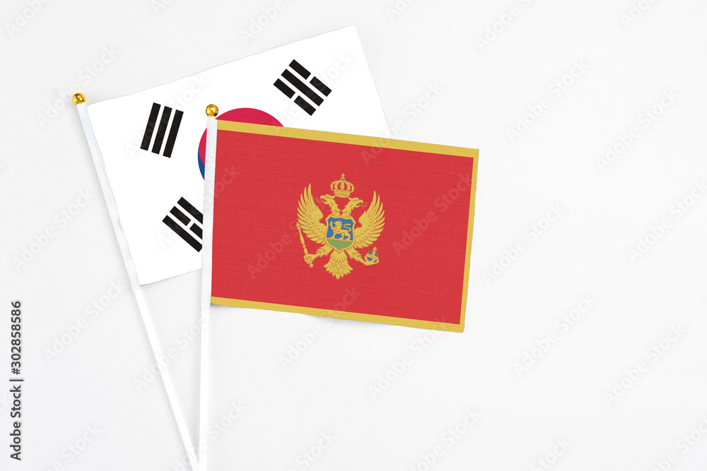 Montenegro and South Korea stick flags on white background. High quality fabric, miniature national flag. Peaceful global concept.White floor for copy space.