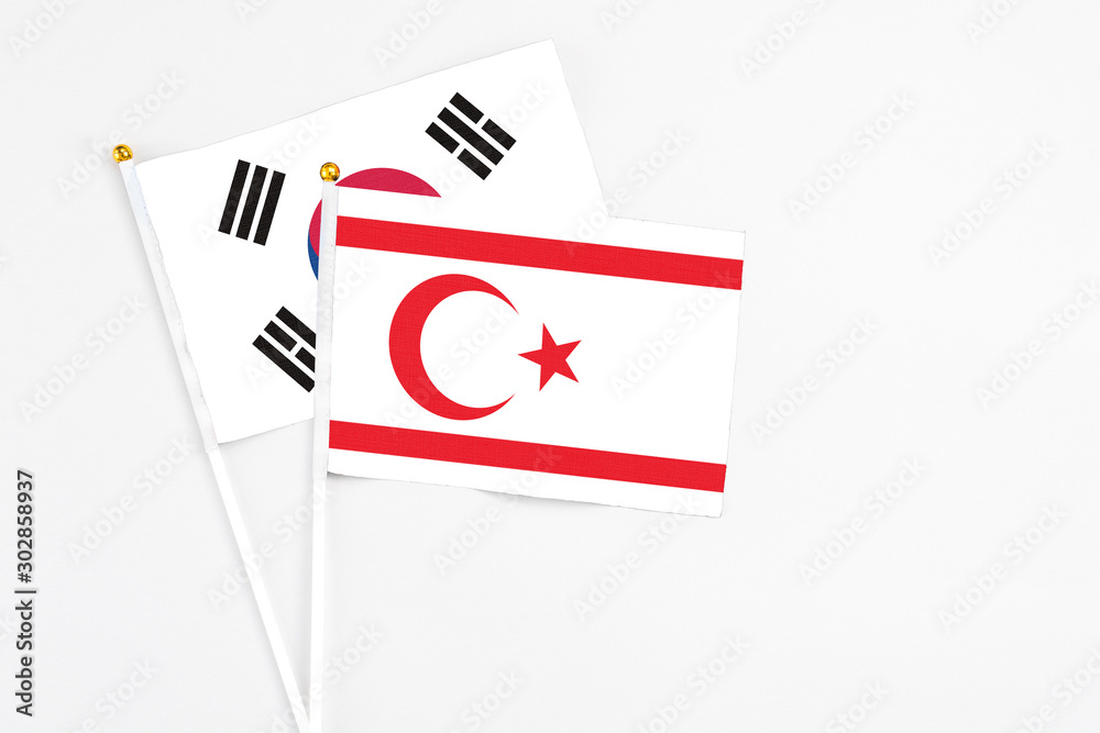 Northern Cyprus and South Korea stick flags on white background. High quality fabric, miniature national flag. Peaceful global concept.White floor for copy space.