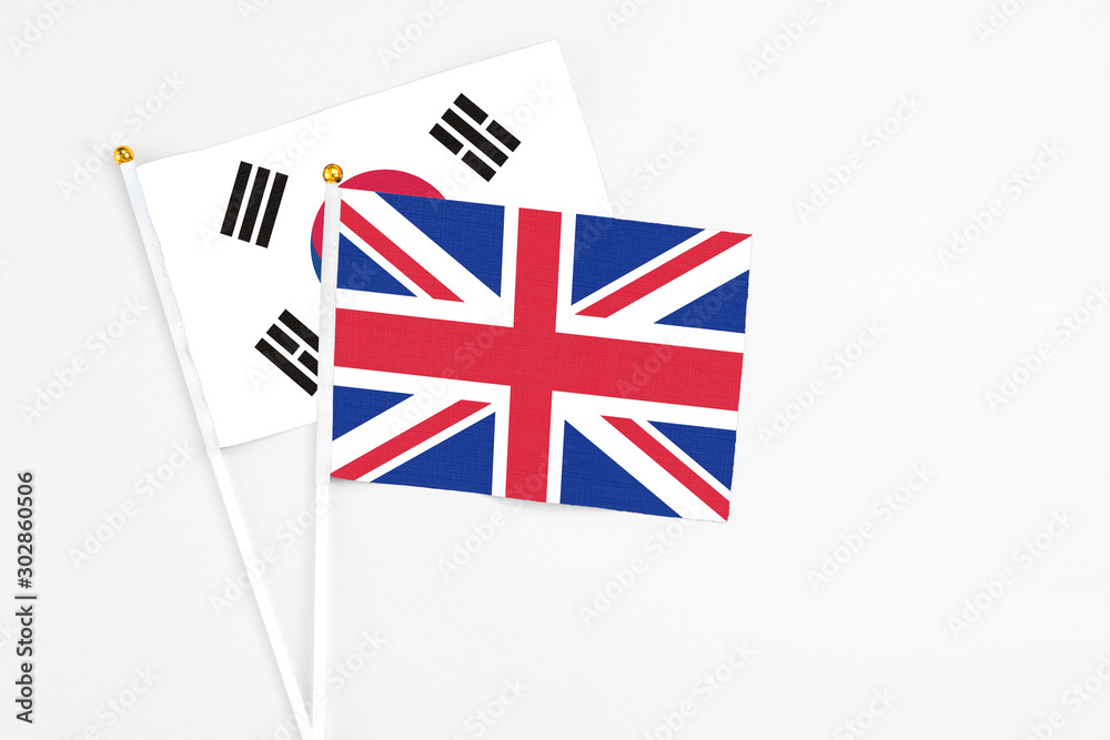 United Kingdom and South Korea stick flags on white background. High quality fabric, miniature national flag. Peaceful global concept.White floor for copy space. United Kingdom and South Korea stick flags on white background. High quality fabric, miniature national flag. Peaceful global concept.White floor for copy space.