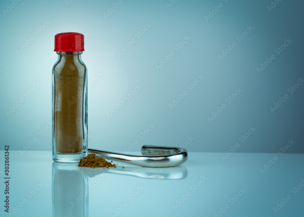 Thai herbal powders snuff in transparent glass bottle with red cap and ...