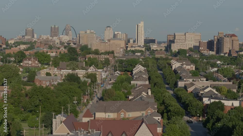 Rise over city neighborhood with downtown St. Louis and Gateway Arch on horizon Rise over city neighborhood with downtown St. Louis and Gateway Arch on horizon