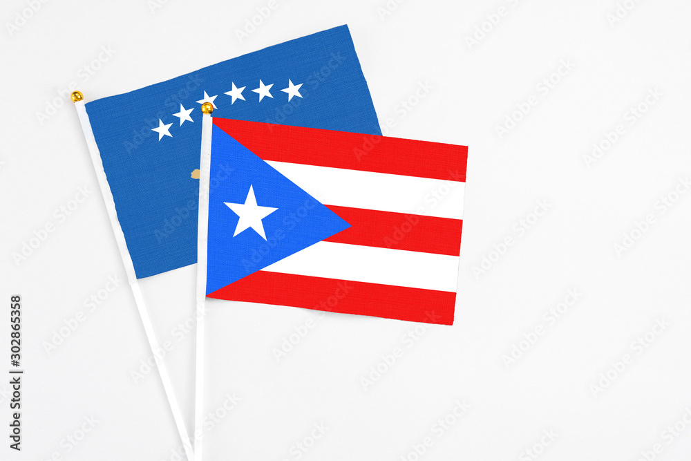 Puerto Rico and Kosovo stick flags on white background. High quality fabric, miniature national flag. Peaceful global concept.White floor for copy space.