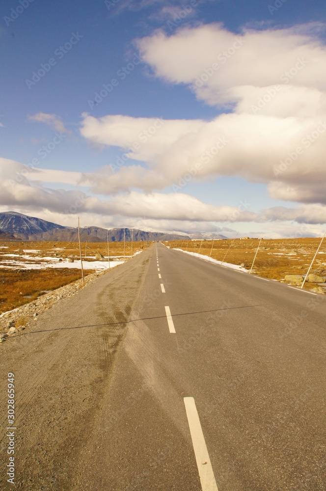 Endlose Straße in Norwegischer Gebirgslandschaft mit Schnee