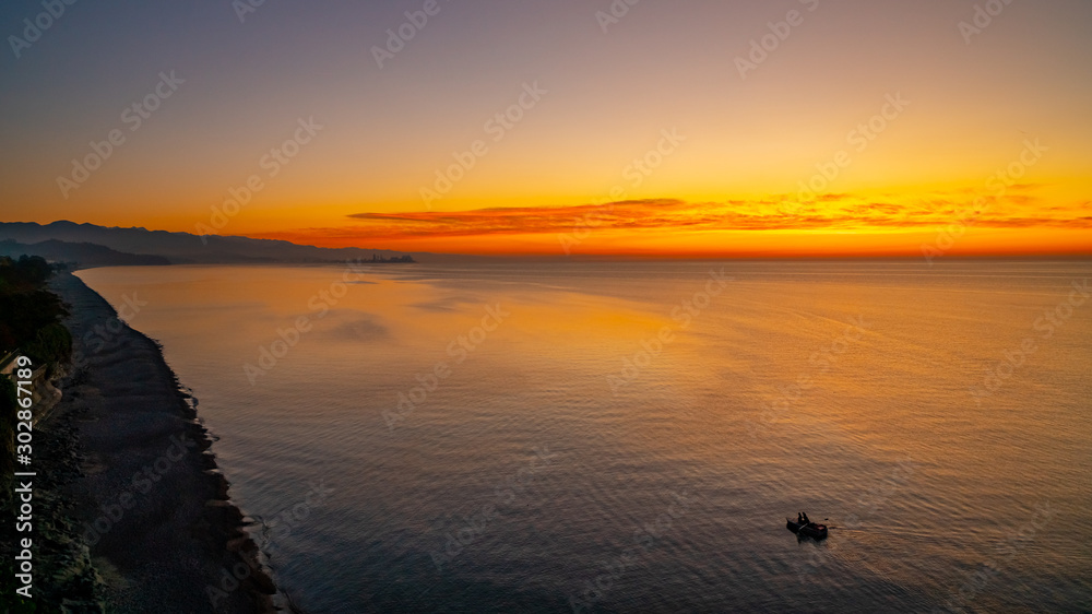 beautiful sunset on the black sea, in the distance is visible the city of Batumi.