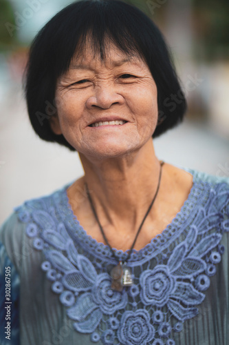 portrait headshot of old asian woman toothy smiling face photo