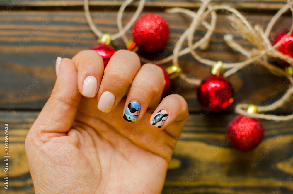 Women's hands with colorful pattern on the nails. Top view. Place for text. cozy winter style. Women's hands with colorful pattern on the nails. Top view. Place for text. cozy winter style.