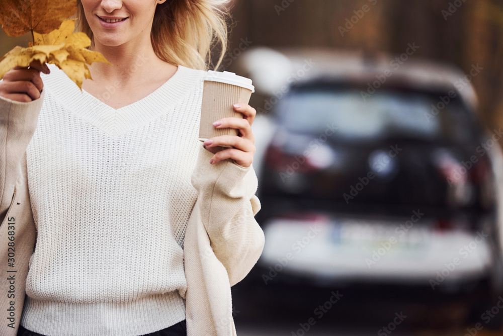 Enjoying nature. Girl have autumn trip by car. Modern brand new automobile in the forest Enjoying nature. Girl have autumn trip by car. Modern brand new automobile in the forest
