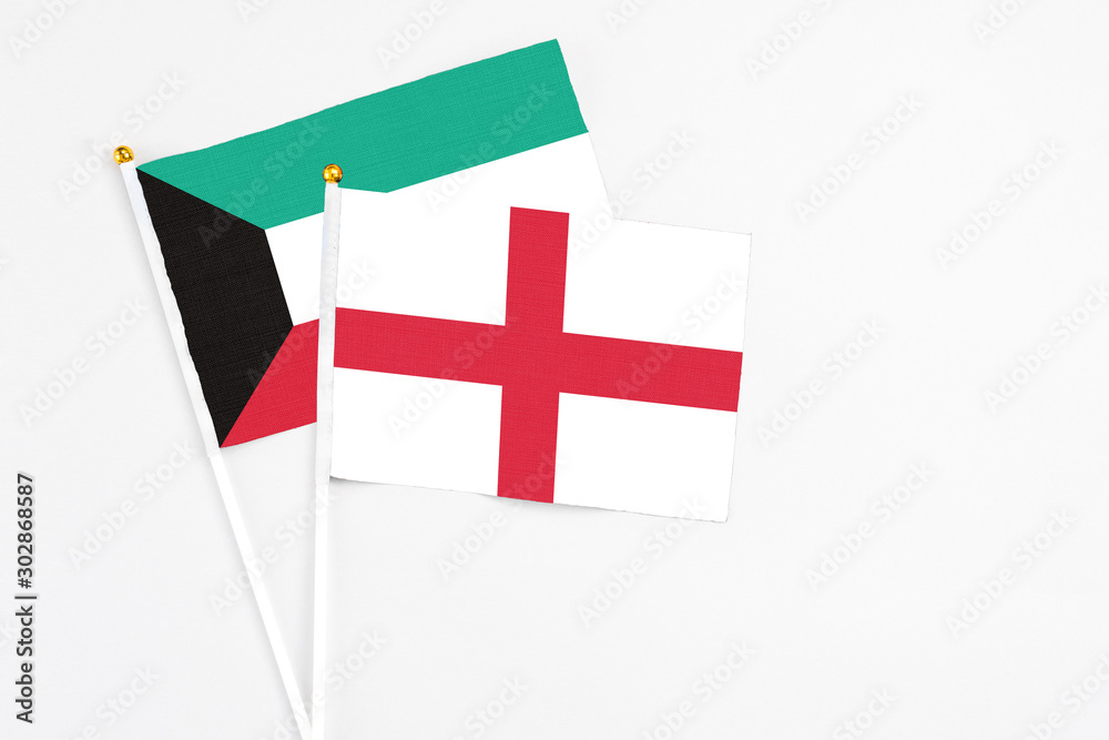 England and Kuwait stick flags on white background. High quality fabric, miniature national flag. Peaceful global concept.White floor for copy space.