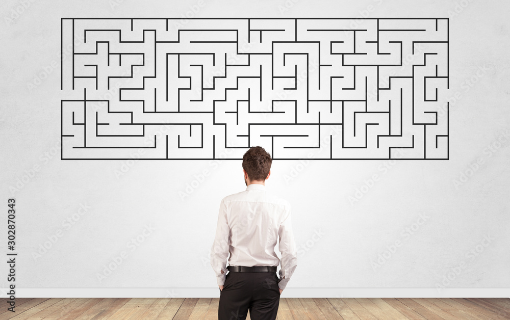 Businessman in doubt looking to a maze and searching the way out Businessman in doubt looking to a maze and searching the way out