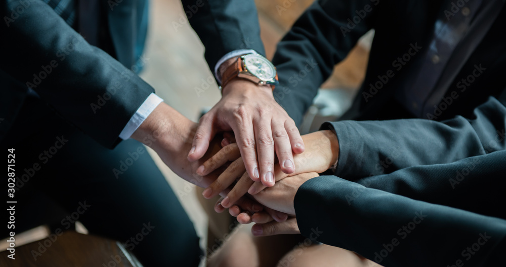 Teamwork of business people stacking hands together in the meeting.