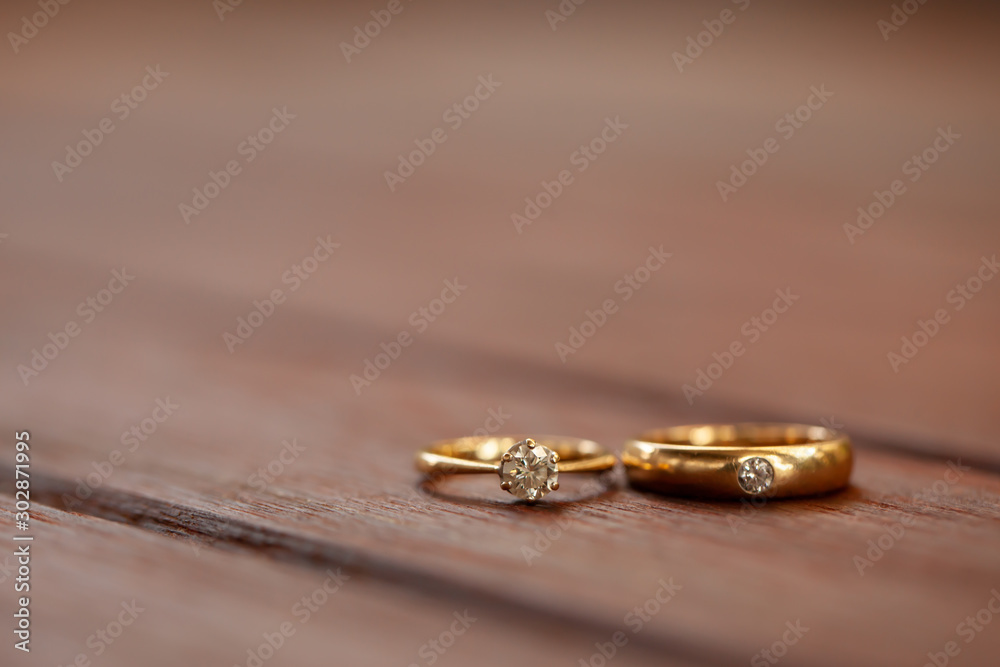 Golden diamond wedding rings on wooden table Golden diamond wedding rings on wooden table