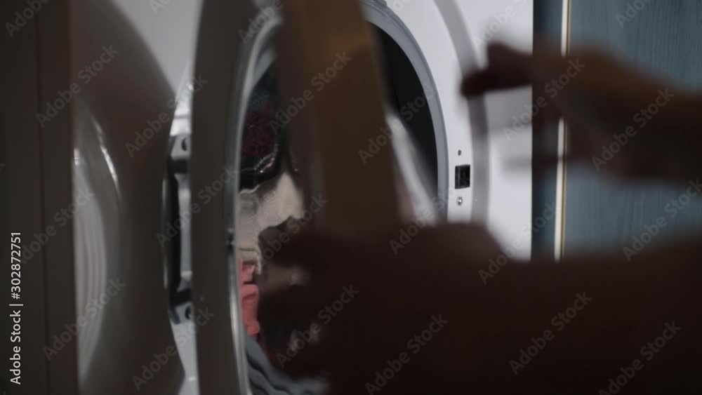 Hand loading washing machine with clothes and closing door Hand loading washing machine with clothes and closing door
