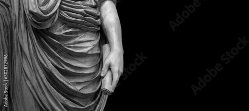 Woman hand on antique tunic. Stone statue detail of human hand. Folds in the fabric. Copyspace for text