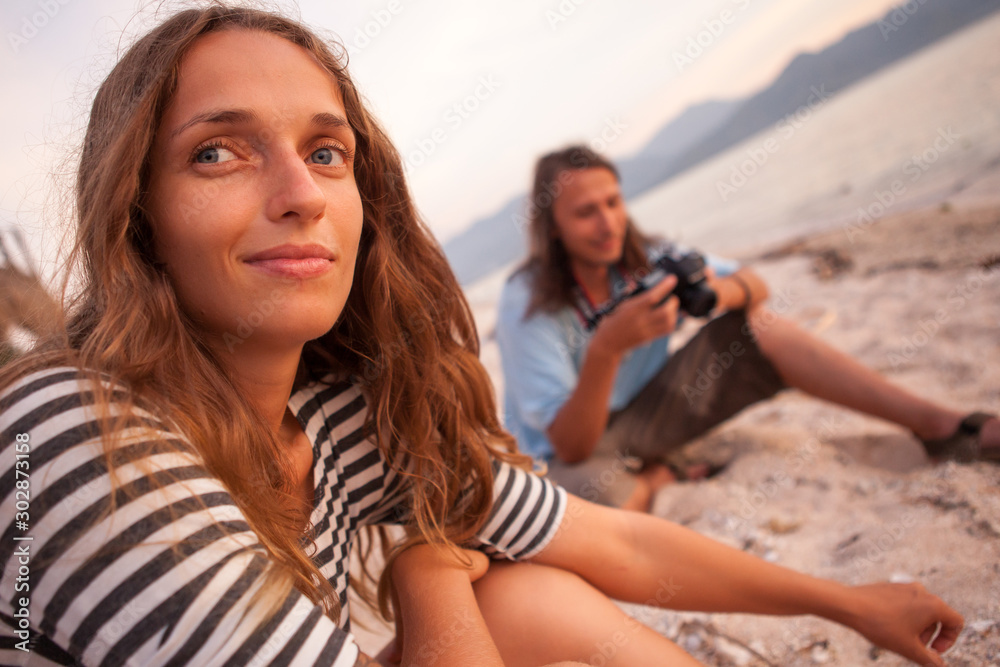 Photographer and a model in summer fashion photo shooting on the beach during sunset time. young beautiful girl Photographer and a model in summer fashion photo shooting on the beach during sunset time. young beautiful girl