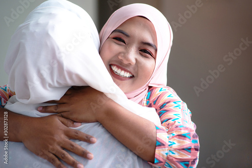 Nice to meet you, close-up of two Asian Muslim women friends meeting in office, Muslim women hugging each other