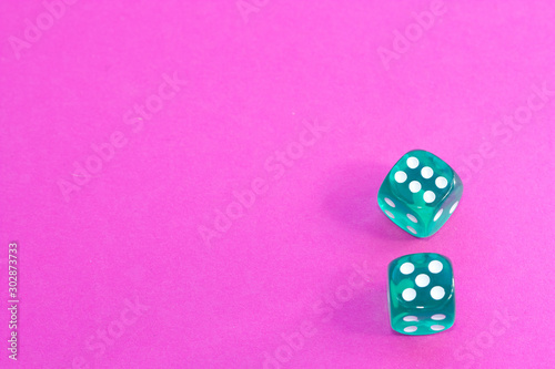 Gambling dices on a pink background.